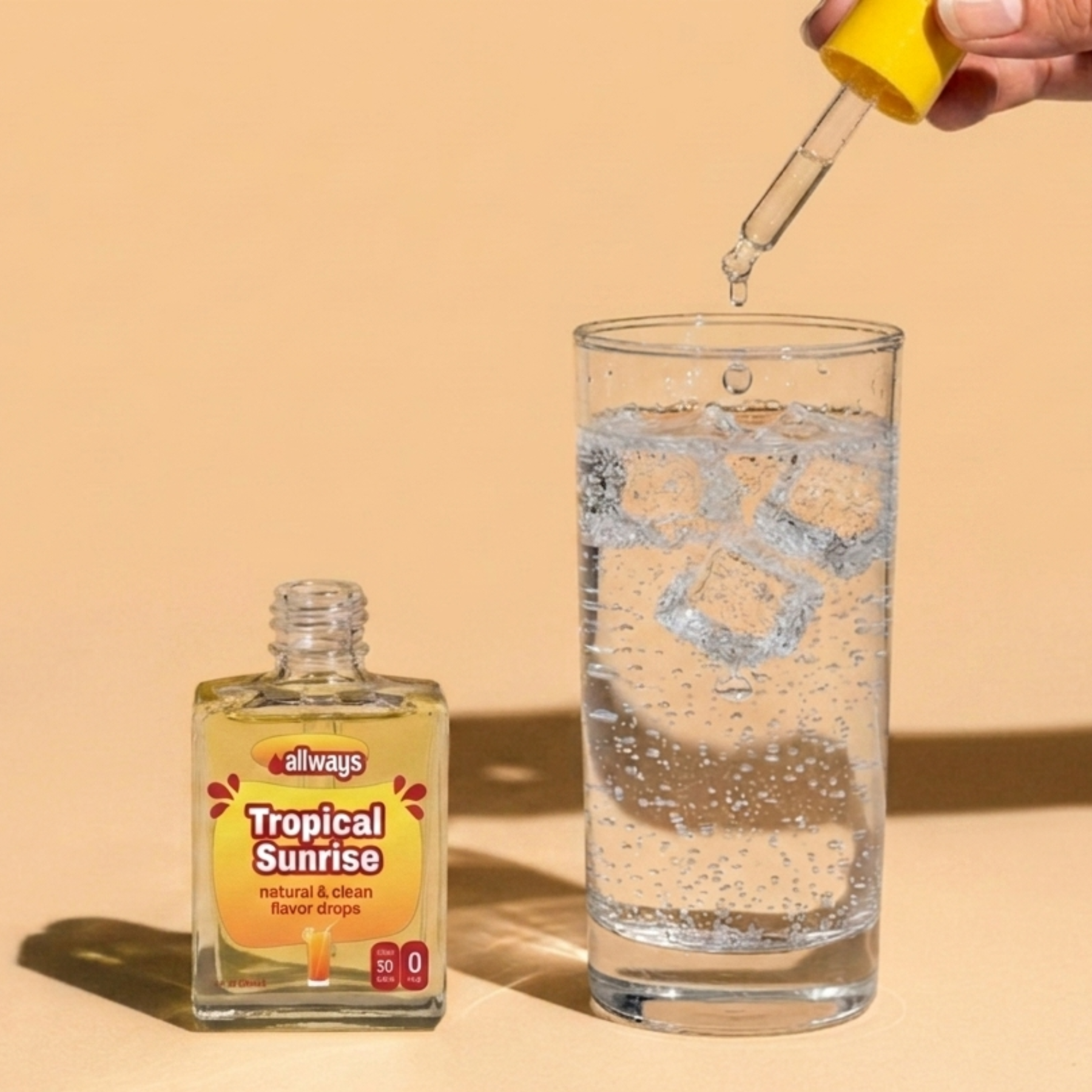 A bottle of Allways Tropical Sunrise natural and clean flavor drops sits next to a tall glass of clear liquid with ice cubes, while a hand holds a yellow dropper above the glass, against a warm beige background.