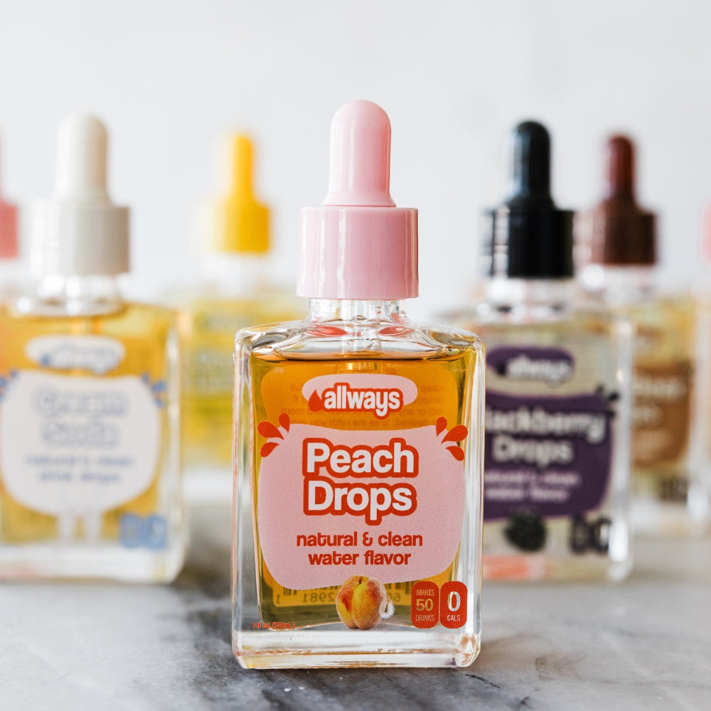 Bottle of 'Allways Peach Drops' water flavor on a marble surface with blurred background